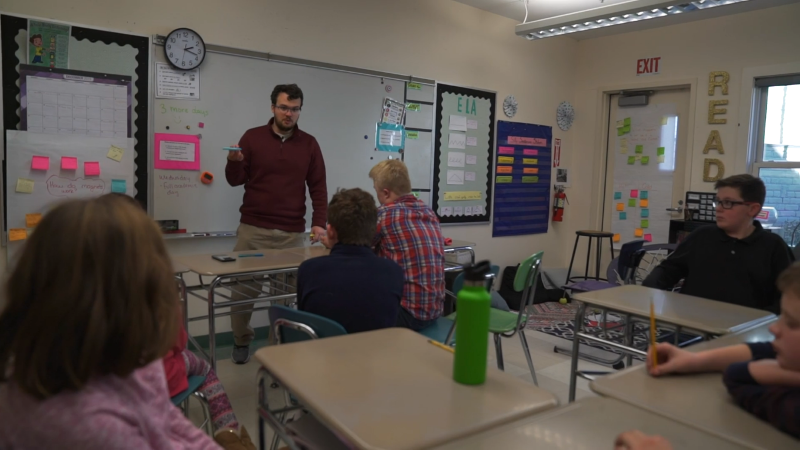 A teacher at Riverview in his class with students learning.